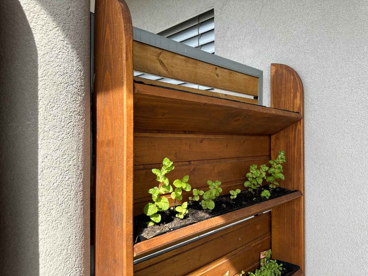 Zábrana od susedného balkóna vytvorená prostredníctvom drevenej vertikálnej bylinkovej záhrady.