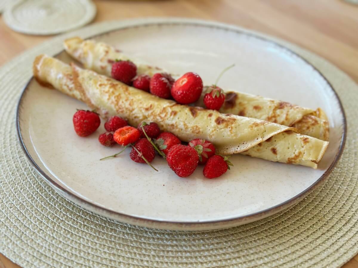 Palacinky ozdobené čerstvými jahodami.