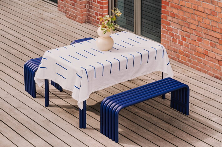 Modrá lavica pri stole s obrusom na terase