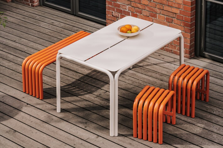 Oranžové stoličky a lavica pri bielom stole na terase